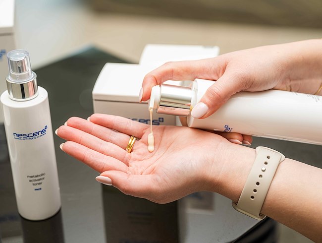 Woman putting lotion product on her hands